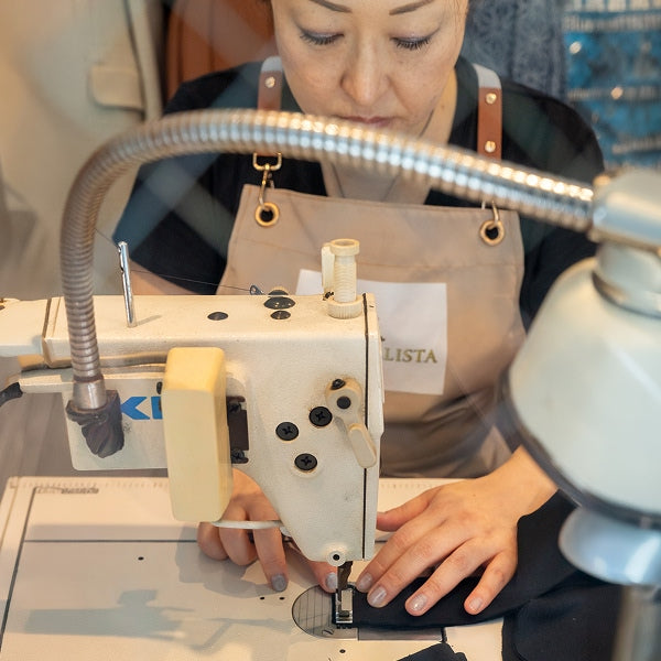 職人の手による縫製（ミシンに向かう職人）